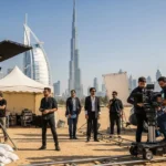 A group of people in the desert with a camera crew, engaged in film production services.