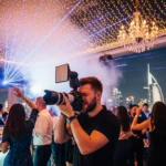 A man captures a photo of guests enjoying a lively party in Dubai, showcasing his skills as a top photographer.